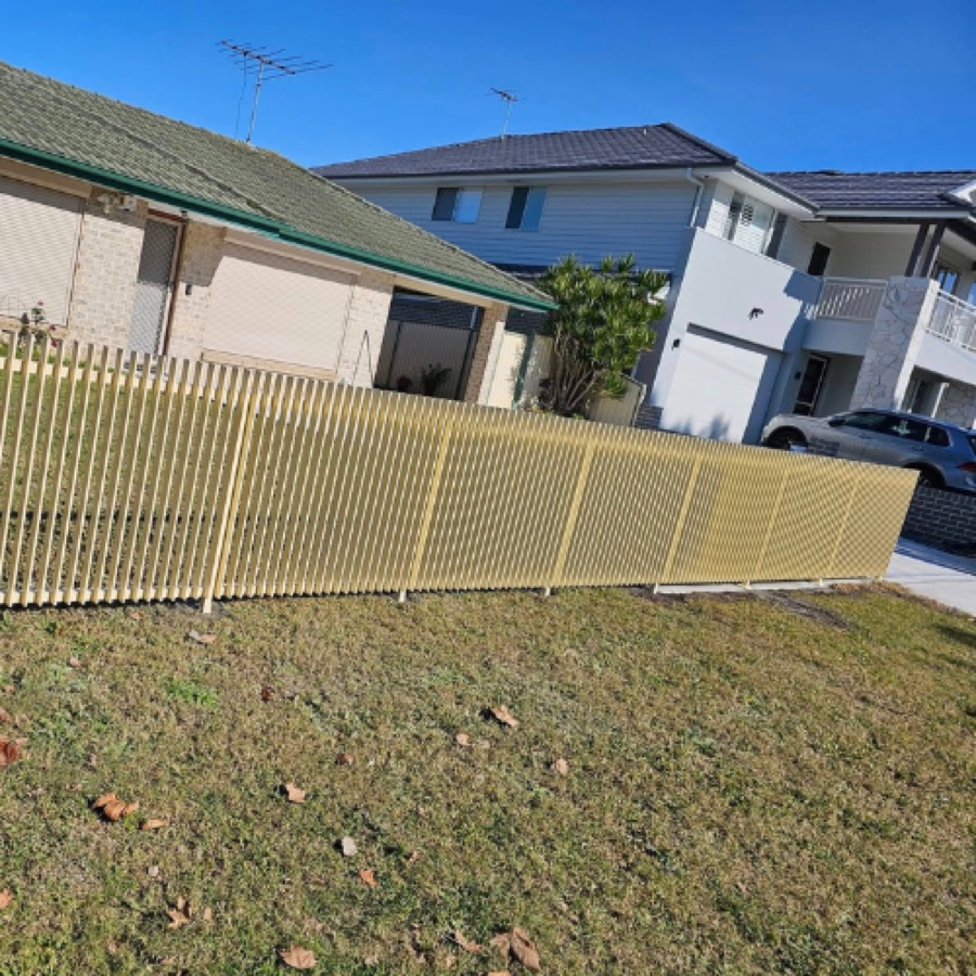 Powder coated vertical slat aluminium fence across a suburban front boundary