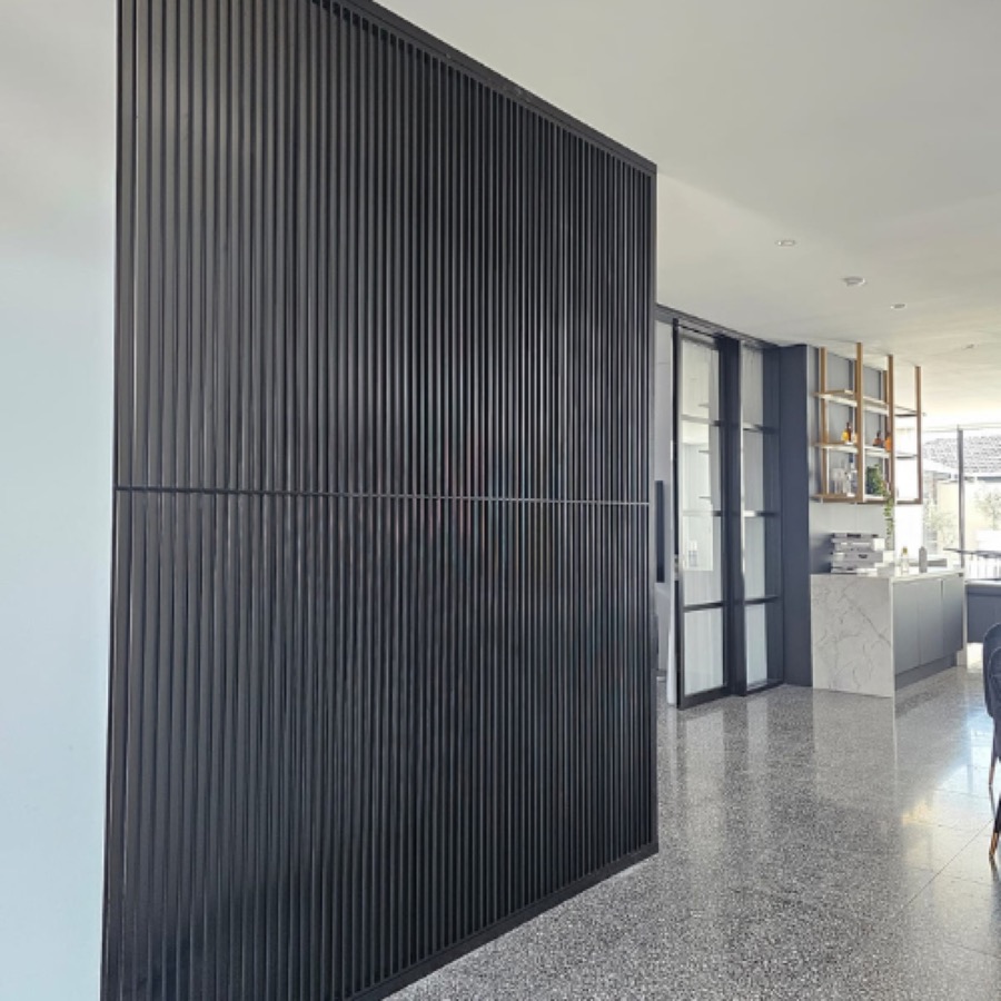 Full-height black aluminium slat screen used as an internal room divider