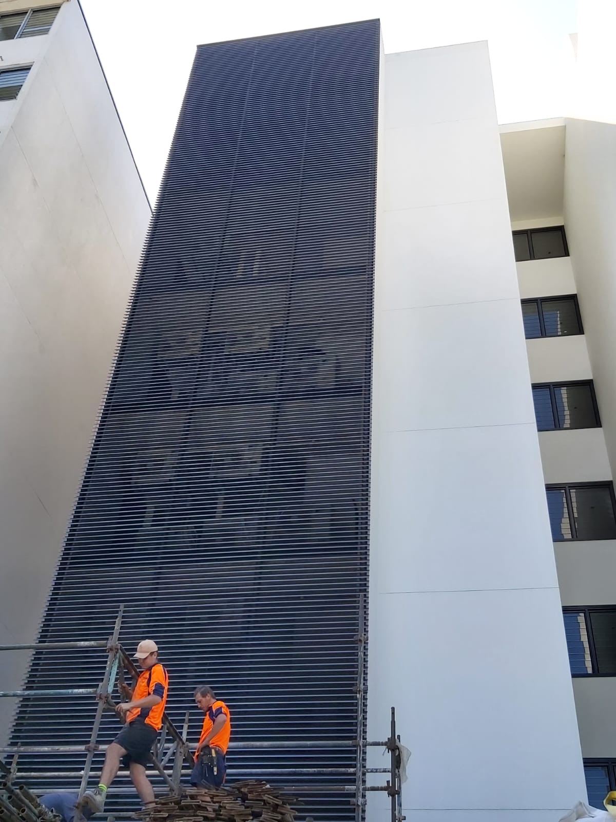 AH Aluminium Fabrication installers on scaffolding fitting a large aluminium louvre screen facade to a commercial building